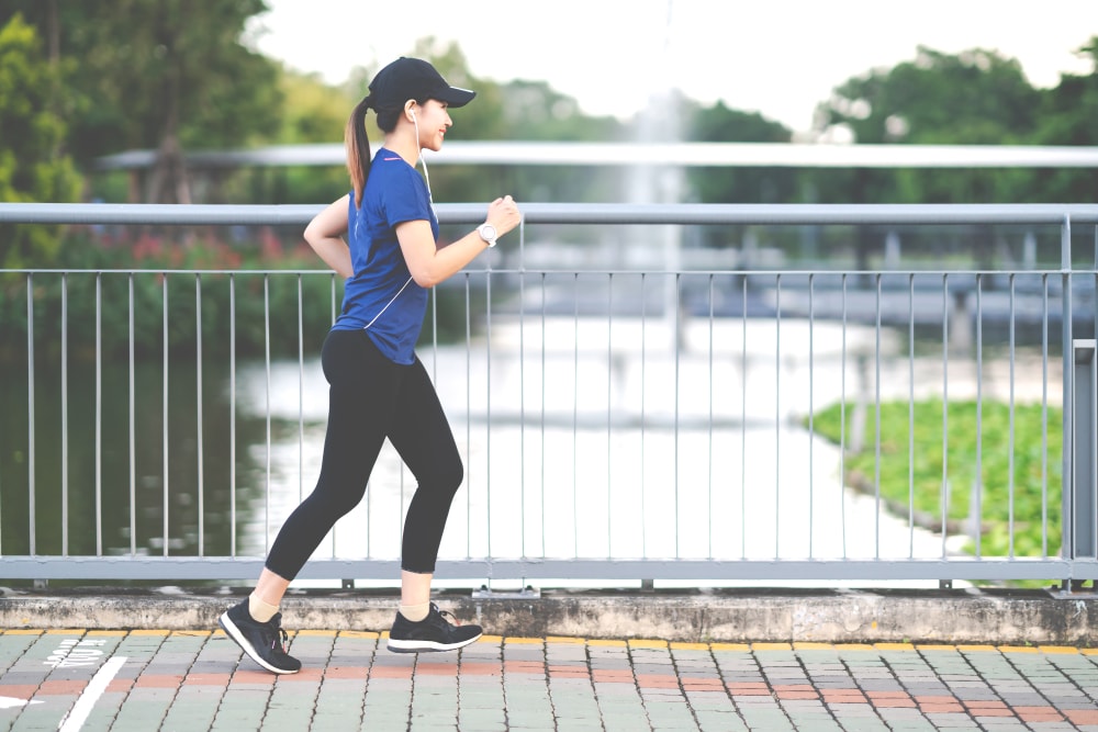 Woman walking for fitness on a bridge