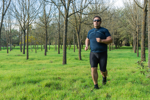 Heavyset man fitness walking in a park