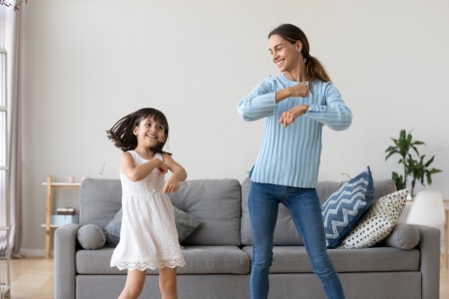 Mom and daughter dancing in living room