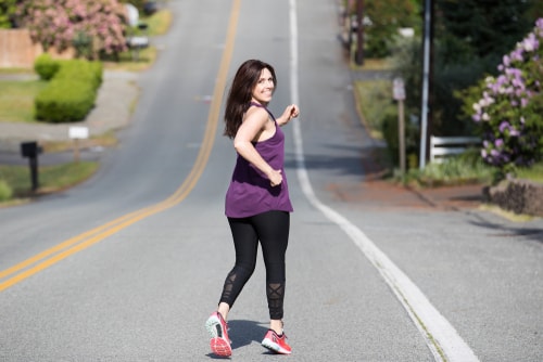 Woman running down a hill for fitness