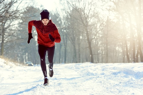 Determined man jogging on a snowy winter road