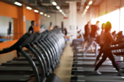 Gym layout with cardio equipment blurred