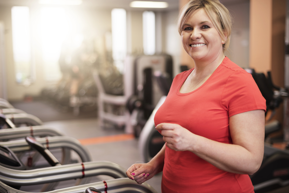 Middle aged woman walking on treadmill
