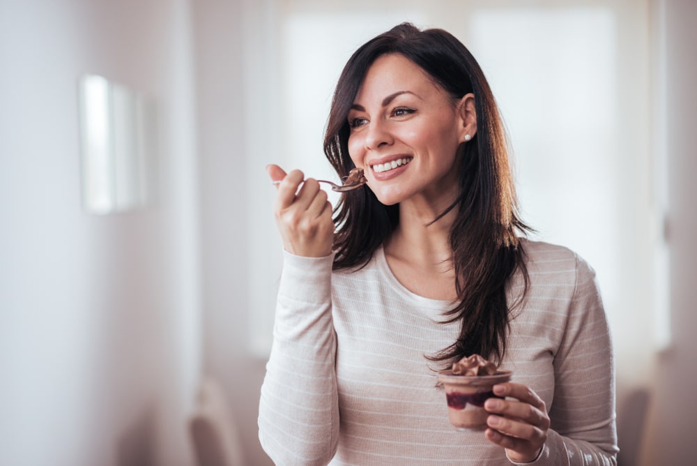 Woman eating a dessert at home