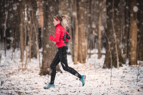 Woman running for fitness on a snowy trail