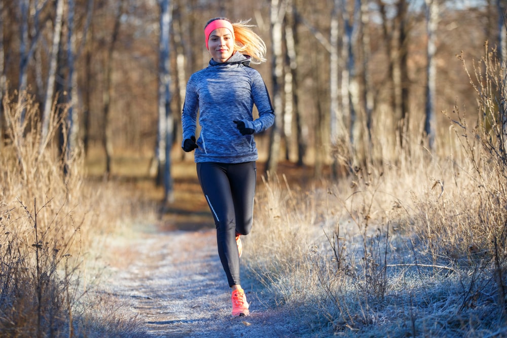 Woman running for fitness in a winter park