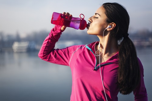 Woman drinking water after a run or walk
