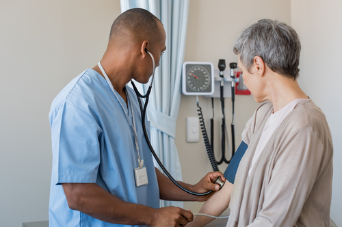 Doctor checking woman's blood pressure