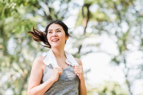 Woman smiling and holding towel after walking