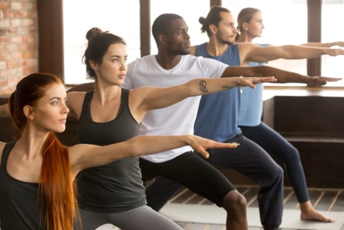 Men and women doing yoga class together