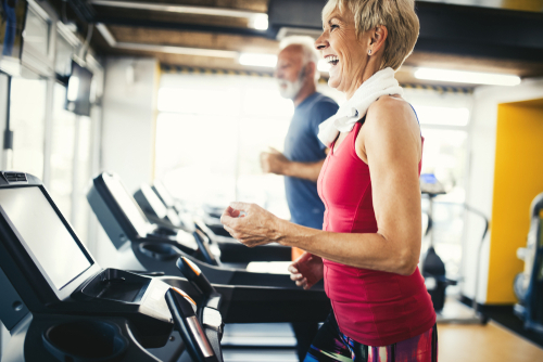 Senior couple walking on treadmills