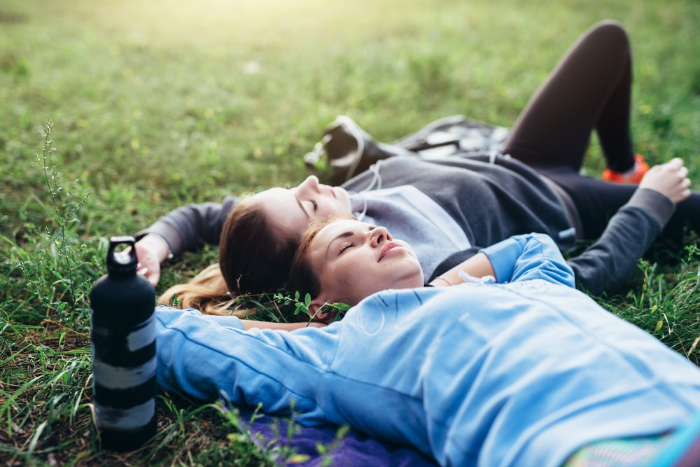 2 athletic women taking a nap in the grass