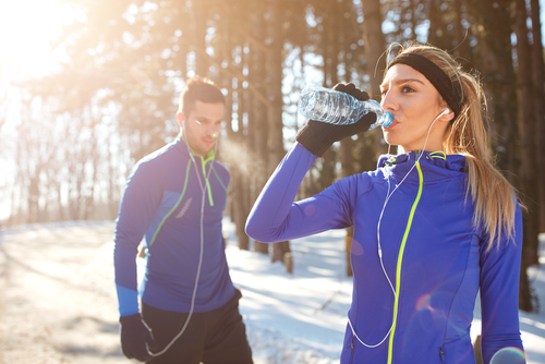 Winter walkers drinking a water bottle