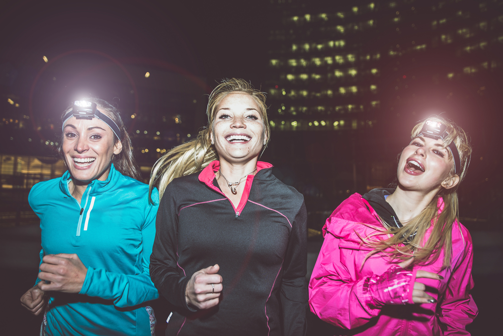 Women running at night with headlamps