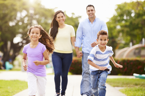Family with young kids walking together in park