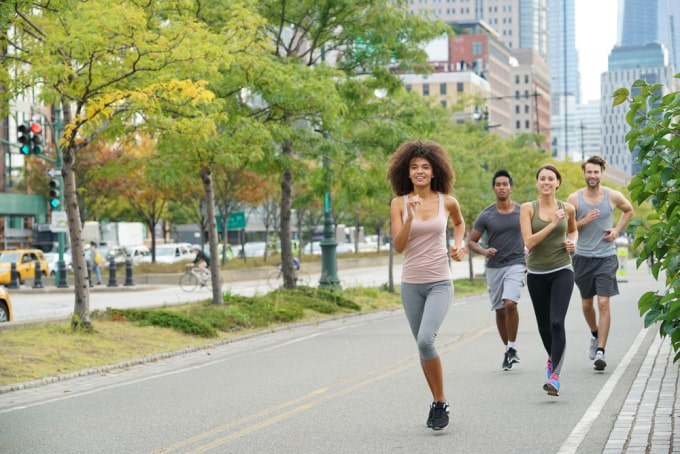 Group of people power walking in a city park