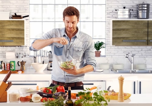 Man making healthy salad cooking at home