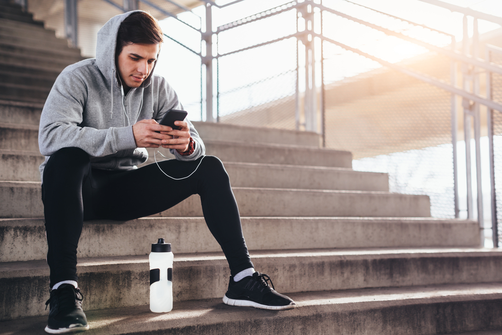 Male athlete checking step counting app