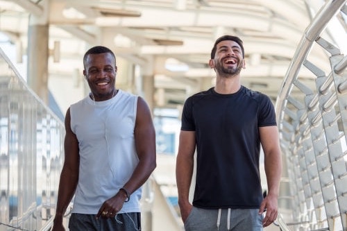 Laughing men walking on bridge for fitness
