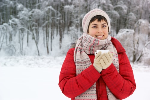 Woman bundled up in snowy park in winter