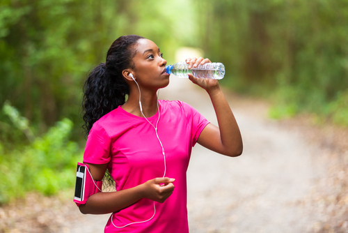 Woman drinking water during a run or walk