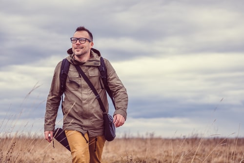 Man hiking in a grassy field