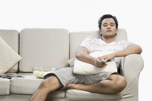 Man lounging on couch watching TV