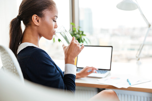 woman drinking water in the office