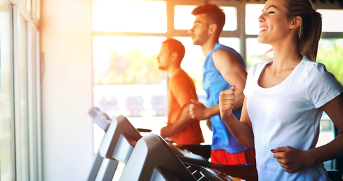 Woman and 2 men running on treadmills