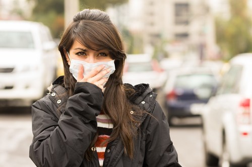 Woman covering mouth with mask because of pollution