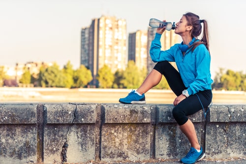 Woman taking a water break during outdoor walk