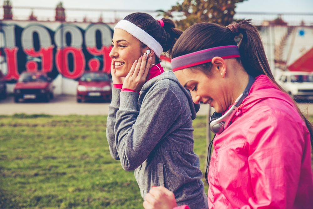 Women running together listening to headphones