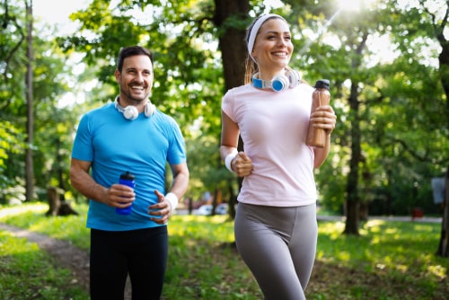 Happy couple walking in the park for fitness
