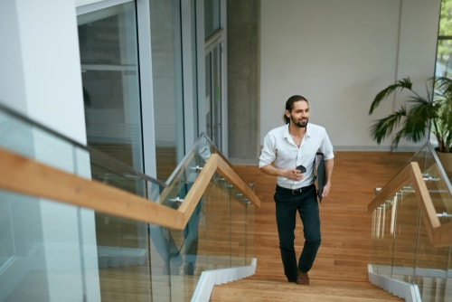 Office worker walking up the steps at work