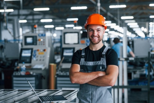Factory worker in work clothes checking computer