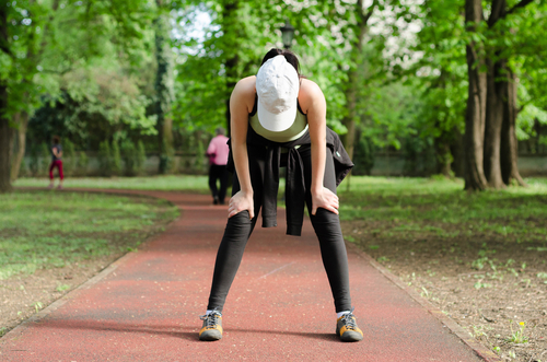 Woman holding her knees after walking