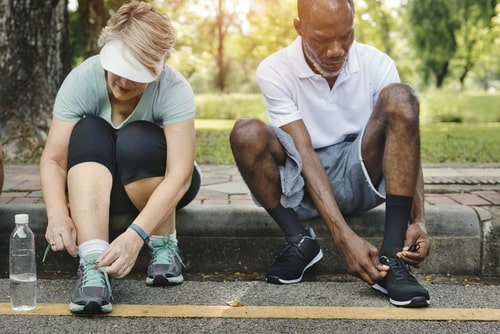 Man and woman tying shoes before a fitness walk