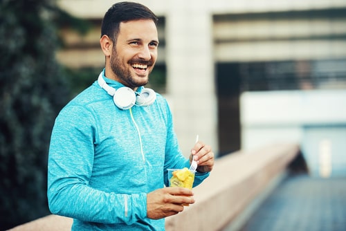 Sporty man eating healthy fruit during a walk