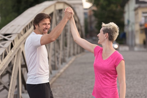 Happy walkers high fiving on a bridge