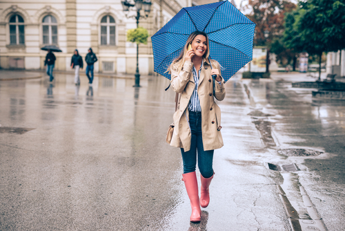 Woman walking in rain with umbrella