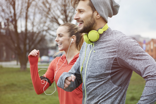 Joggers smiling while jogging in park