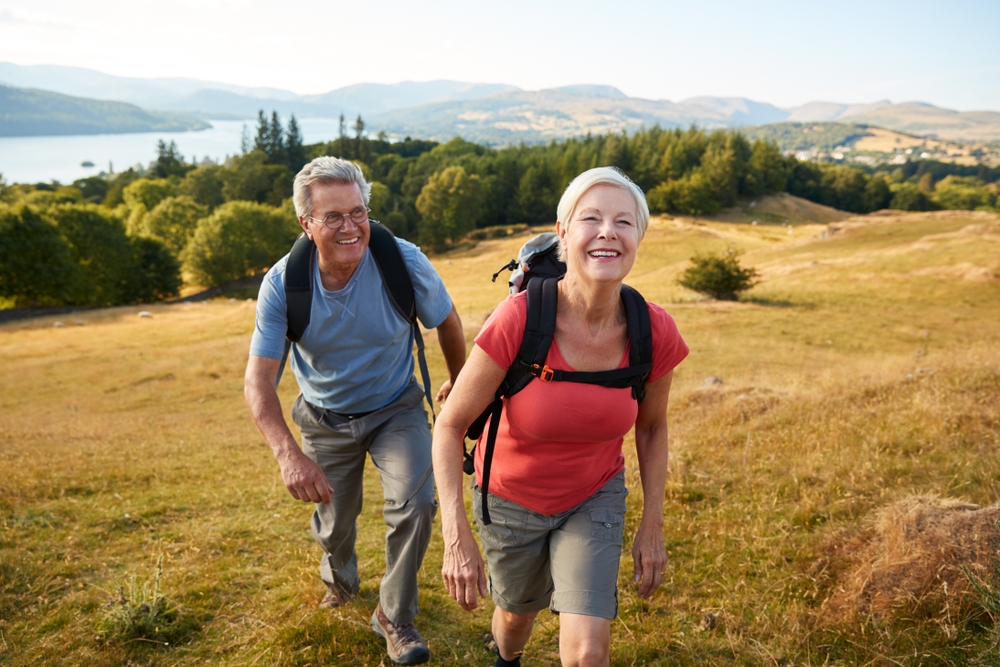 Senior couple hiking up a hill in the countryside